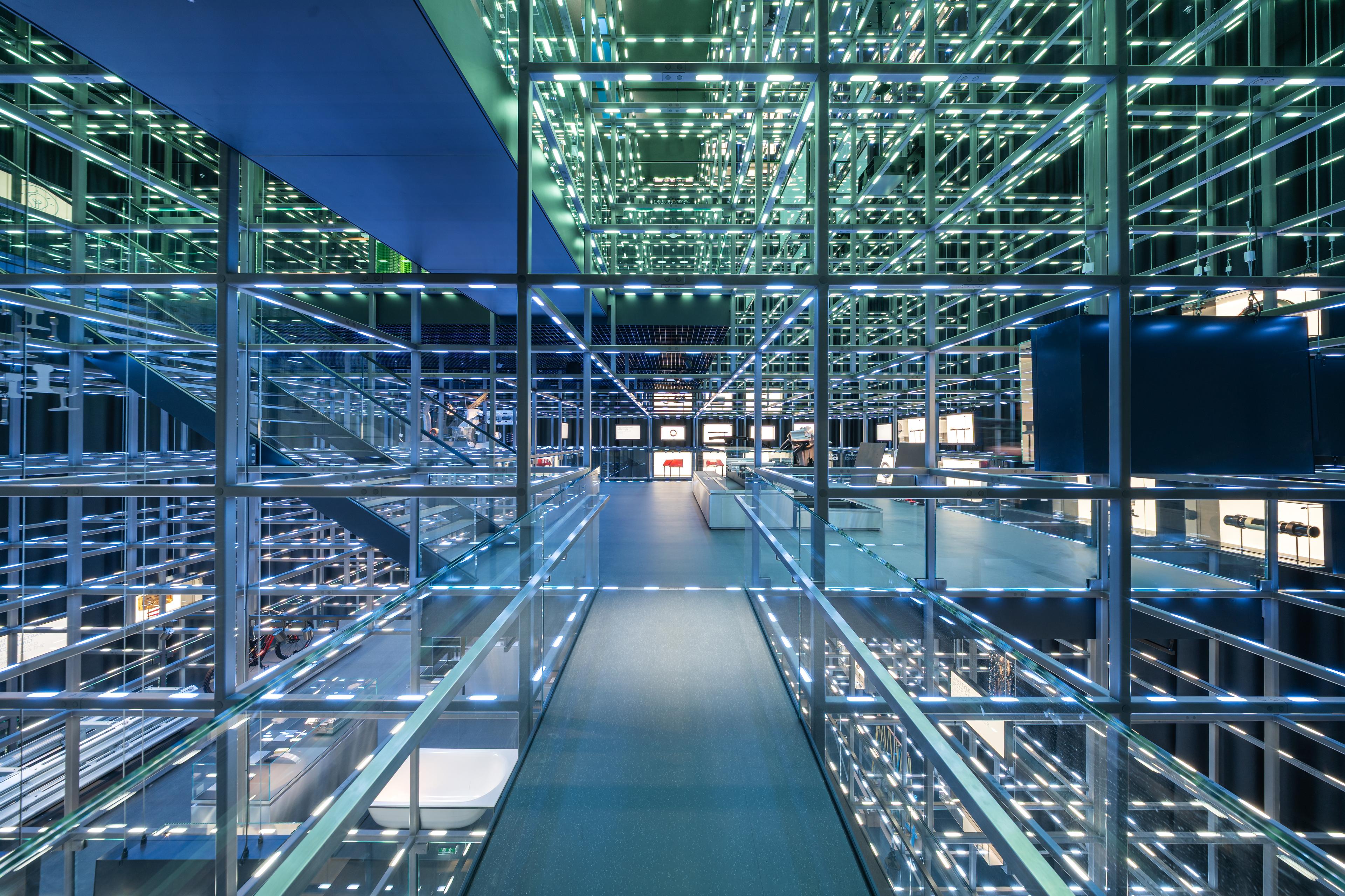 Visitors move through the illuminated Grid, a suspended steel structure with integrated lighting that forms the architectural centerpiece of the voestalpine Stahlwelt
